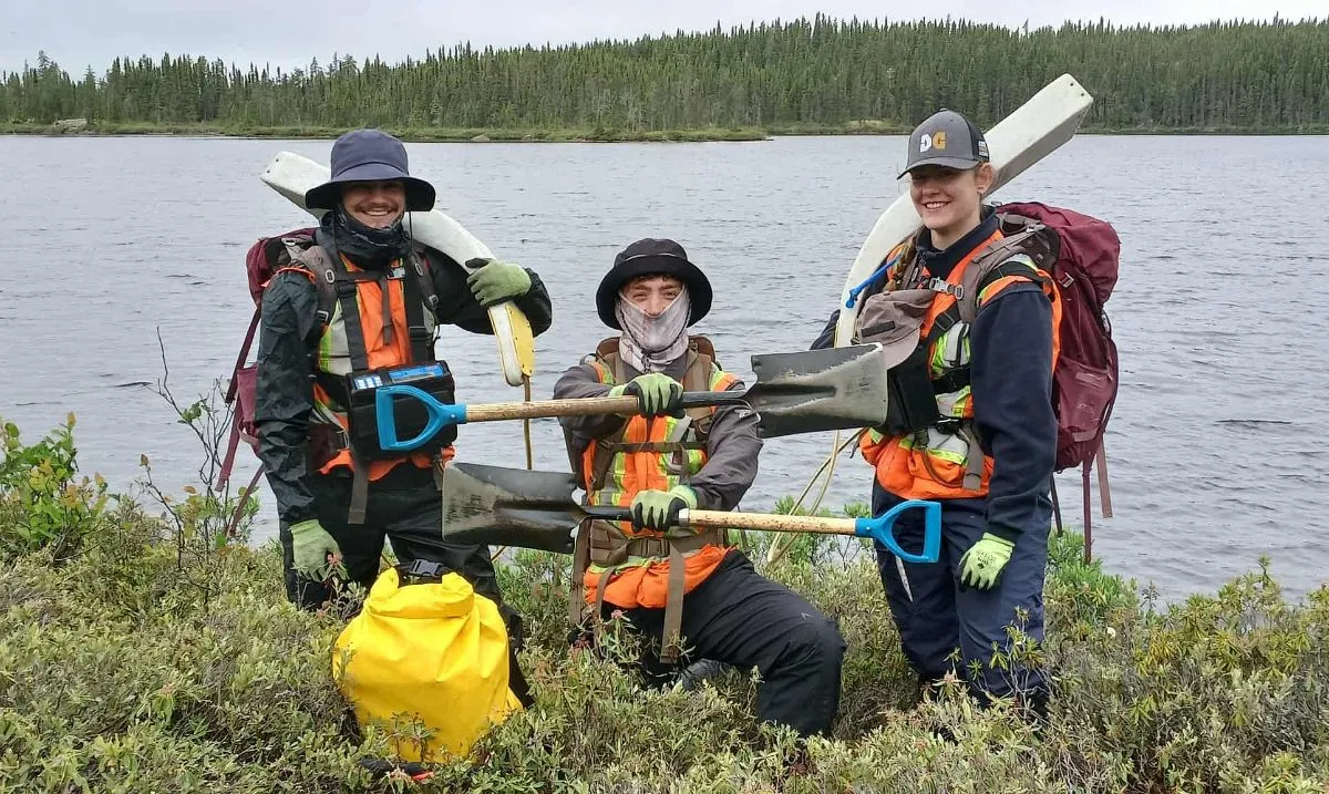 Three crew members with Beep Mat detectors on a lakeshore