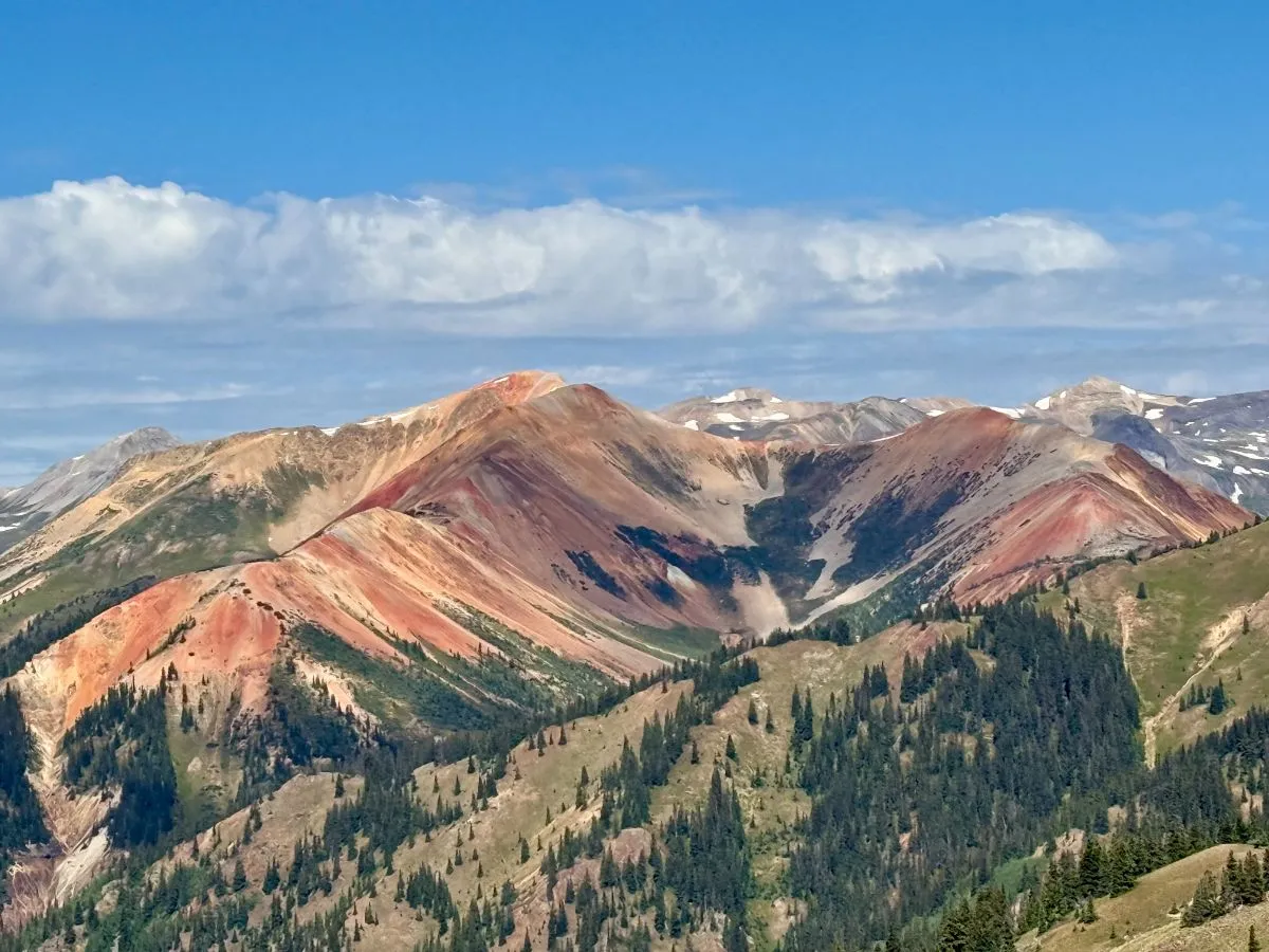 Red mountain slopes above a forested valley