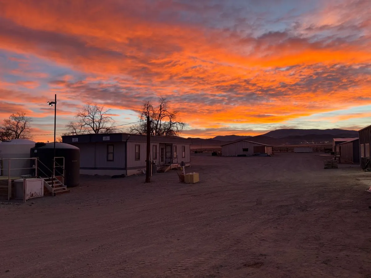 Exploration camp trailers under a pink and orange sunset in Nevada