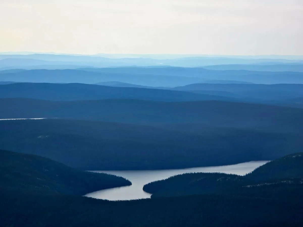 Layered blue ridges above a winding river