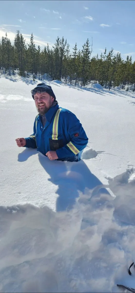 Geologist waist-deep in snow on a winter road