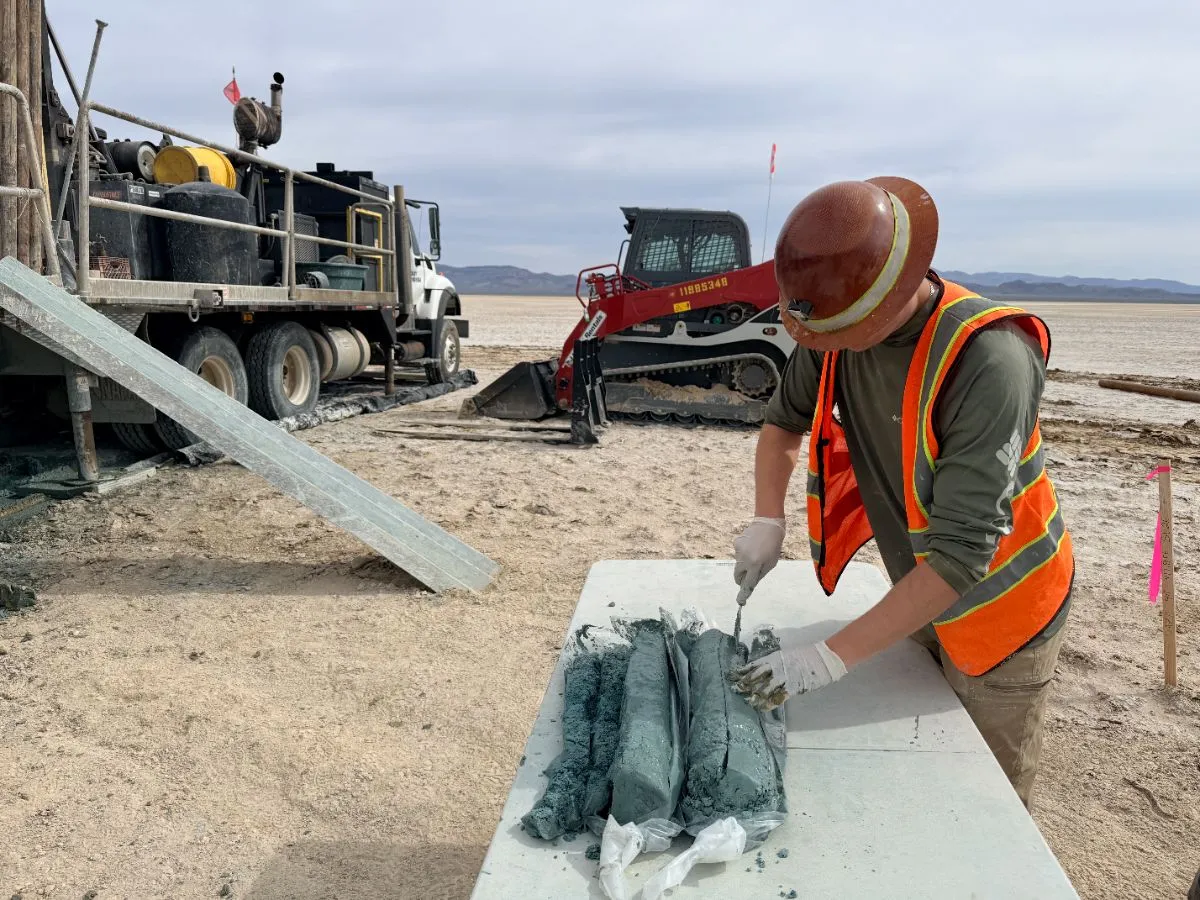 Technician cutting sonic core on a table beside the rig