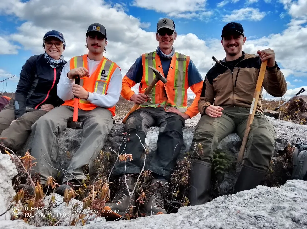Field crew with rock hammers sitting on an outcrop at Cisco