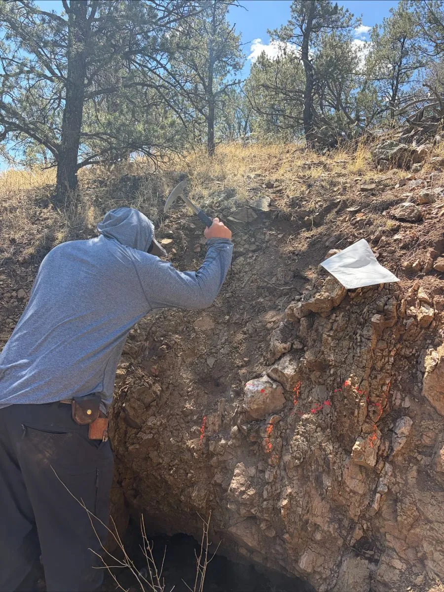 Geologist examining a red rock outcrop
