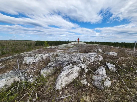 Geologist standing on a pegmatite outcrop at the Cisco project