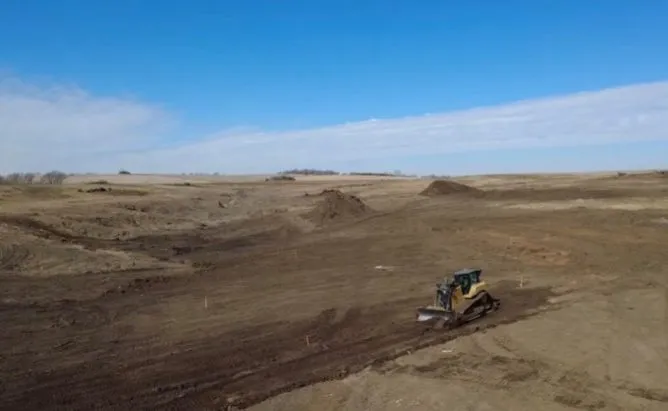 Bulldozer clearing a drill pad on open farmland at Elk Creek, Nebraska