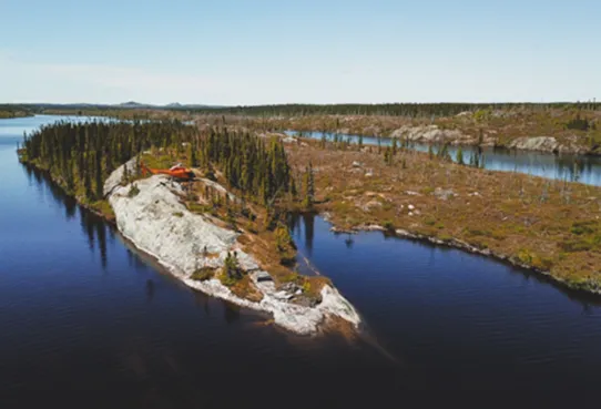 Aerial view of a lakeside exploration camp on a rocky point in the James Bay boreal forest